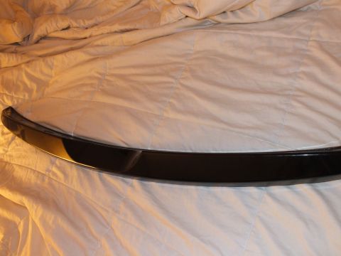 2003 Ford Crown Victoria - Black decklid spoiler stood vertically across a gray comforter