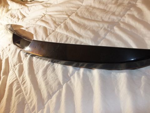 2003 Ford Crown Victoria - Black rear spoiler shown at an angle on a wrinkled comforter