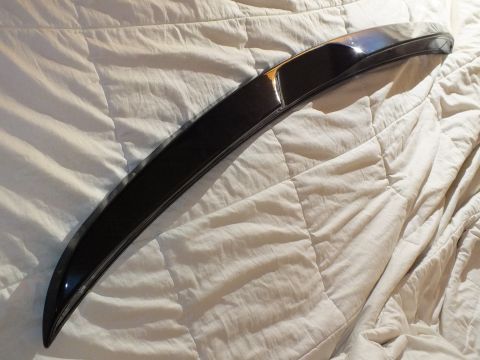 2003 Ford Crown Victoria - Black rear deck spoiler stretched diagonally across a comforter