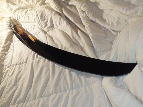 2003 Ford Crown Victoria - Black trunk lip spoiler photographed top-down on a quilted bedspread