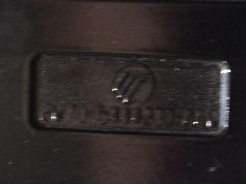 2003 Ford Crown Victoria - Macro of a recessed Mercury emblem stamped into a black molded part