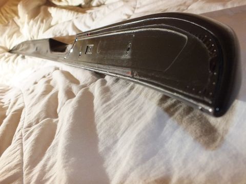 2003 Ford Crown Victoria - Molded gloss black body trim shown from below with attachment holes along its tapered edge.