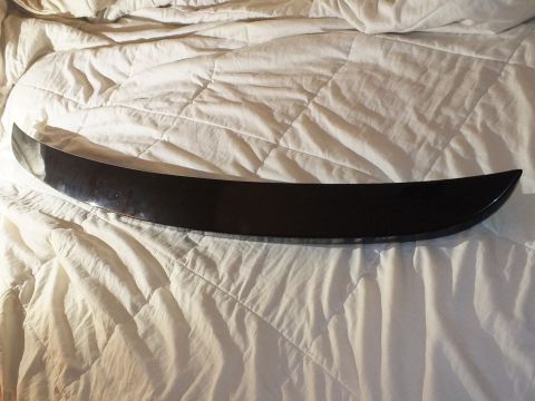 2003 Ford Crown Victoria - Full-length view of a tapered black trim spoiler stretched across a white quilted bed.