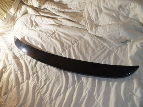 2003 Ford Crown Victoria - slim curved black trim strip laid diagonally on a white quilted bedspread.