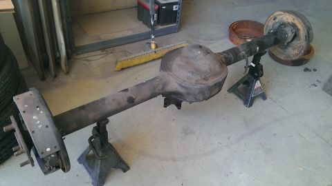 1978 Ford Bronco - This rear axle assembly is supported by jack stands, showing brake components and the differential housing.
