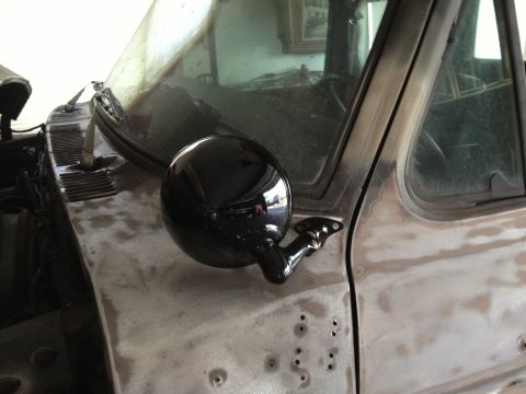 1979 Ford F-350 - The side mirror and door panel of a 1979 Ford F-350 are visible, with the body appearing to be in a state of repair.