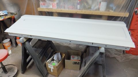 1983 Ford Bronco - A white tailgate rests on sawhorses, ready for work in a garage setting.