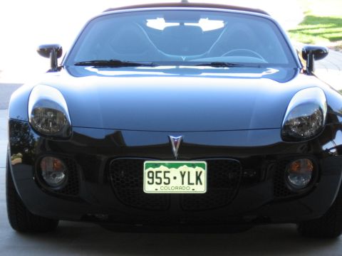 1995 Ford Bronco - Front view of a black Pontiac Solstice with a honeycomb grille and a Colorado license plate.