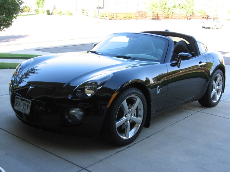 Black Pontiac Solstice coupe front three-quarter view on a driveway