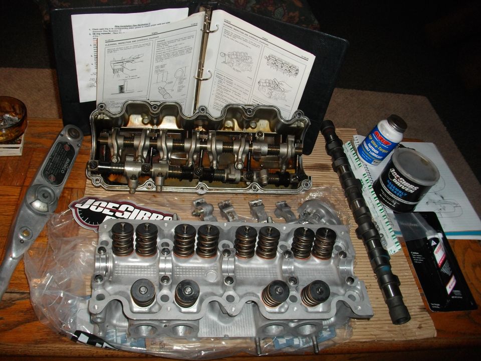 Engine cylinder head, camshaft, and assembly manual on a table