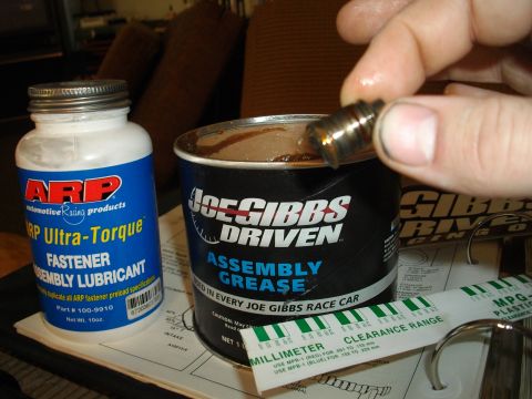 1989 Ford Probe - Assembly lubricants and a small metal part are shown, likely for engine or vehicle maintenance.