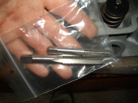 1989 Ford Probe - Close-up of two taps, one marked M12x1.50, held in a plastic bag.