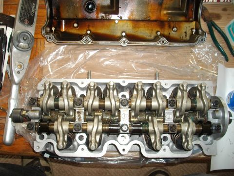 1989 Ford Probe - Disassembled engine cylinder head and valve cover with a torque wrench nearby.