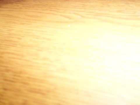 1989 Ford Bronco - The image shows a blurred wooden surface with a bright light source on the right side.