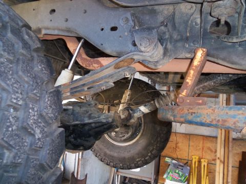1989 Ford Bronco - Underside view of a vehicle's rear suspension system, showing the axle, shocks, and leaf springs.