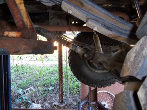 1989 Ford Bronco - Close-up view of the undercarriage, focusing on the rear suspension system with visible rust and wear.