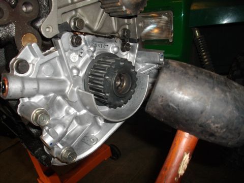 1989 Ford Probe - Close-up of an engine component with a gear and a mallet nearby. Part number DA167 is visible on the component.