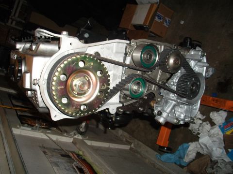 1989 Ford Probe - Engine assembly with timing belt and pulleys visible, mounted on an orange engine stand.
