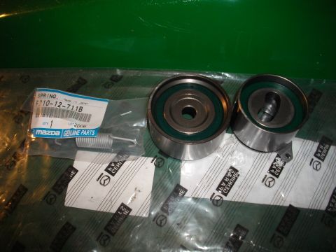 1989 Ford Probe - Car parts, including belt tensioner pulleys and a spring, are shown with Mazda genuine parts labeling.