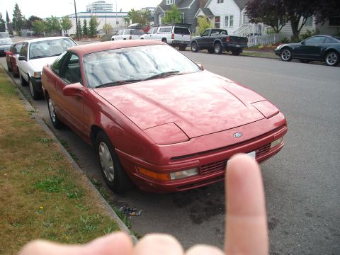 1989 Ford Probe - A red 1989 Ford Probe is parked on a residential street.
