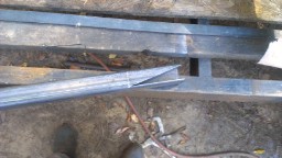 1978 Ford Bronco - Metal beams and debris are visible on the ground, possibly at a construction or scrap site.