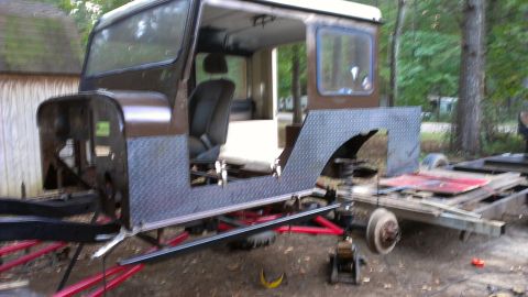 1978 Ford Bronco - A brown Jeep CJ-5 body is seen on a trailer, undergoing restoration with its front fenders and hood removed.