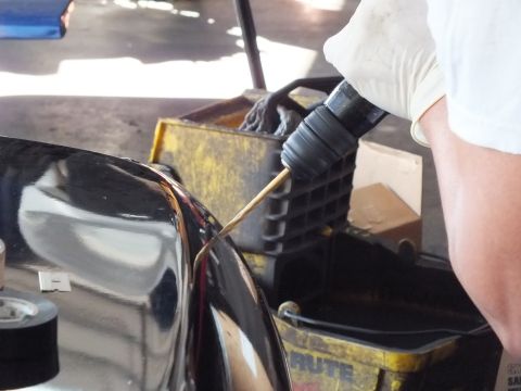 2003 Ford Crown Victoria - Close view of a drill bit cutting into a black painted panel over BRUTE collection bins.