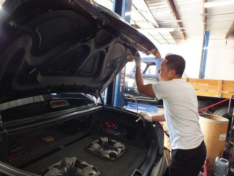 2003 Ford Crown Victoria - Raised trunk reveals an audio install with two subwoofers as a man works overhead.