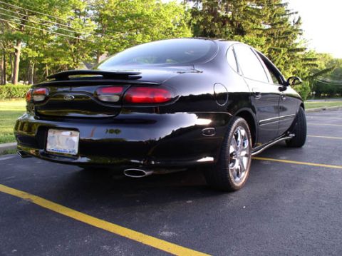 1998 Ford Taurus - Black 1998 Ford Taurus sedan parked on asphalt with yellow lines.