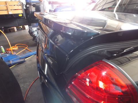 2003 Ford Crown Victoria - Close view of a black car's illuminated red taillight and rear trim during service