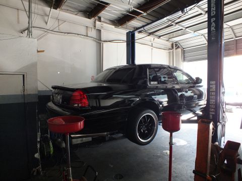 2003 Ford Crown Victoria - Rear three-quarter of a black Crown Victoria raised on a lift in a repair shop