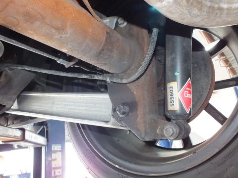 2003 Ford Crown Victoria - Undercarriage shot showing a rear shock absorber and component tagged 555603 by the wheel