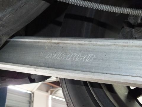 2003 Ford Crown Victoria - Aluminum suspension brace embossed METCO seen from below a lifted sedan