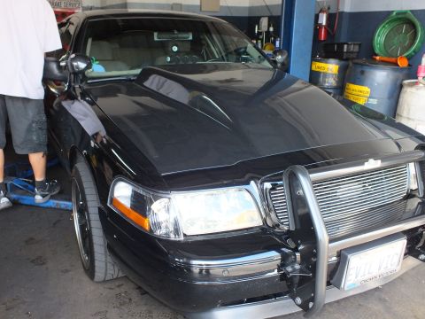 2003 Ford Crown Victoria - Hood and front fascia of a black Crown Victoria with billet grille, brush guard and EVIL VIC plate