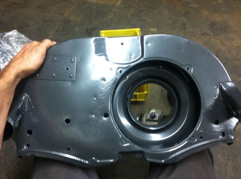 1970 Volkswagen Beetle - A person holds a painted engine shroud, likely for a classic Volkswagen, in a workshop setting.