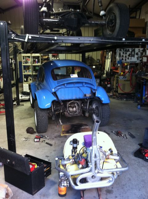 1970 Volkswagen Beetle - A blue Volkswagen Beetle is being worked on in a garage, with its engine removed and placed nearby.