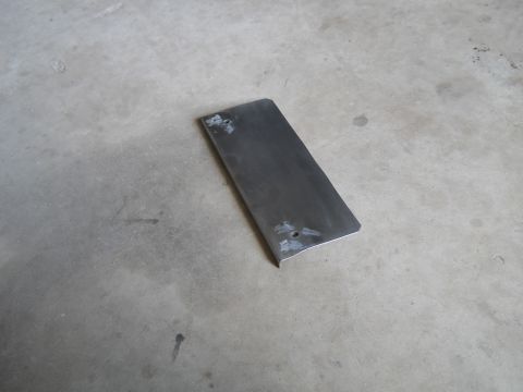 1992 Ford Bronco - A metal plate rests on a concrete surface, showing signs of wear and two drilled holes.