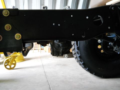 1992 Ford Bronco - The underside of a vehicle, focusing on the frame and a large off-road tire.