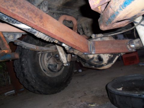 1989 Ford Bronco - Underbody view of a vehicle's rear axle and suspension system, showing rust and wear.