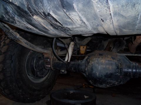 1989 Ford Bronco - The rear axle and suspension components of an unidentified vehicle are visible from below.
