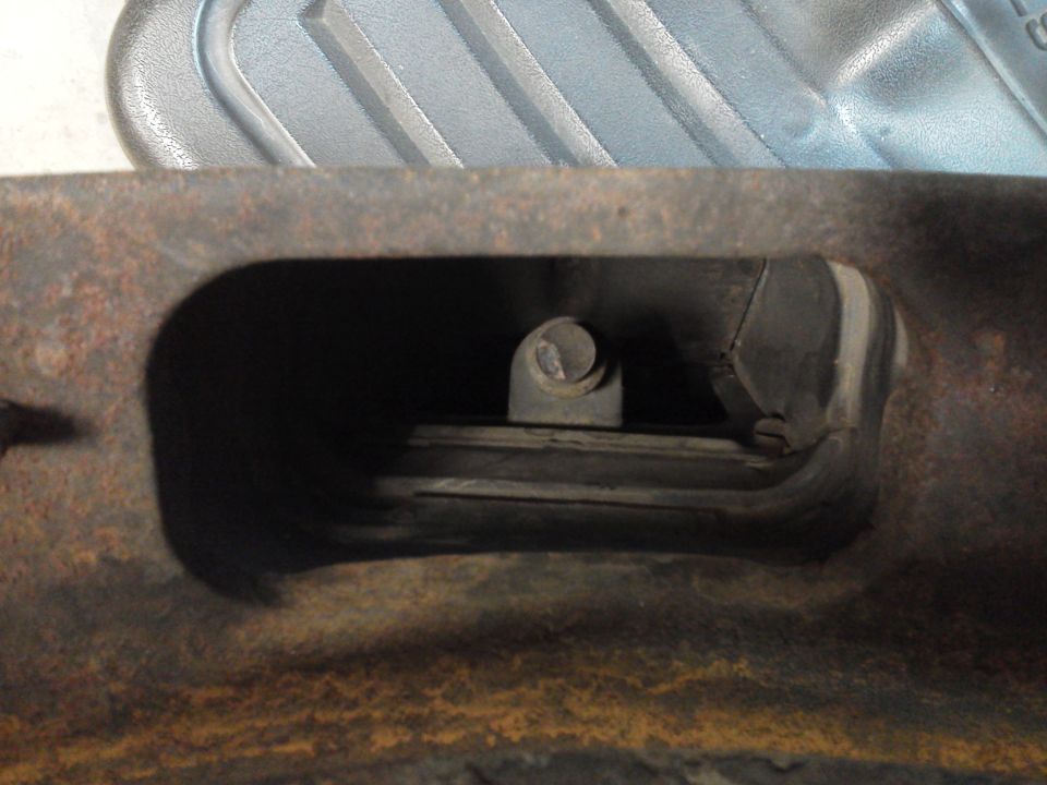 Close-up of a metal engine component with a bolt and rubber bushing