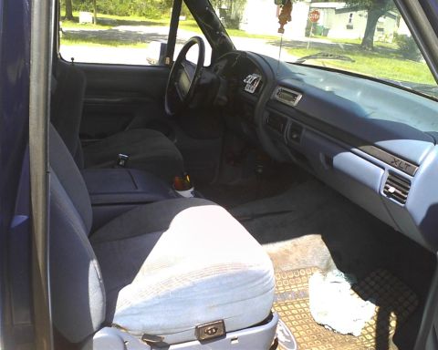 1996 Ford Bronco - The interior of a 1996 Ford Bronco, cloth seats and a blue dashboard.