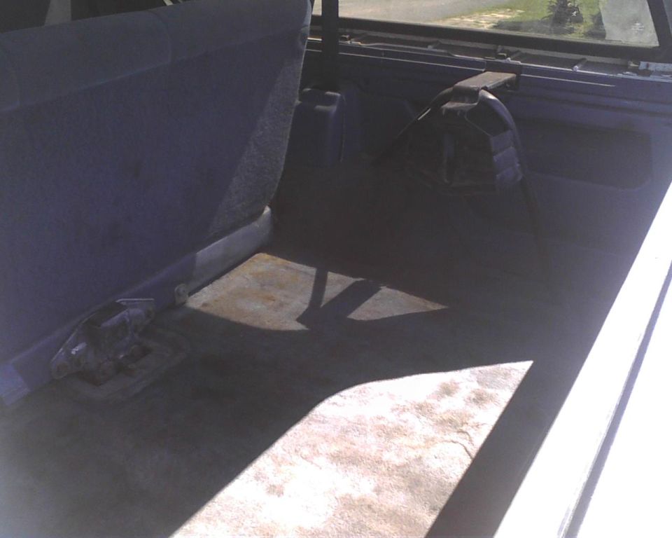 Rear cargo area of a vehicle with folded-down seats and a spare tire cover