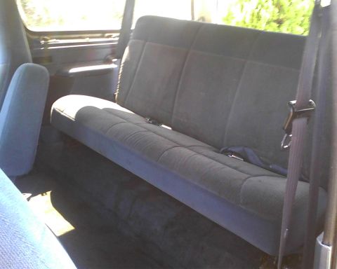 1996 Ford Bronco - The rear interior of a 1996 Ford Bronco is visible, with a focus on the bench seat and seatbelt.