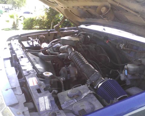 1996 Ford Bronco - Engine bay of a 1996 Ford Bronco, an aftermarket blue air filter and visible engine components.