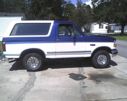 1996 Ford Bronco - Side view of a 1996 Ford Bronco with a white lower body and blue upper body.