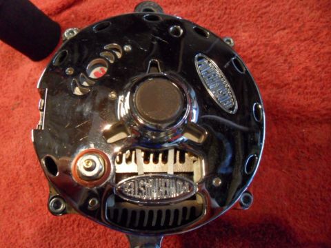 1994 Jeep Cherokee - A shiny chrome alternator is shown up close, resting on a red textured surface.
