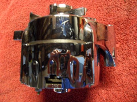 1994 Jeep Cherokee - A chrome alternator housing is shown against a red background, with its reflective surface mirroring the camera and surroundings.