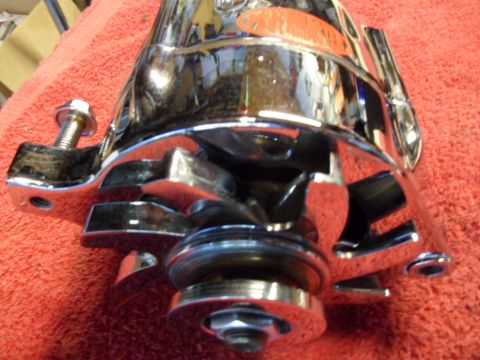 1994 Jeep Cherokee - A shiny chrome alternator is shown up close, resting on a red textured surface.