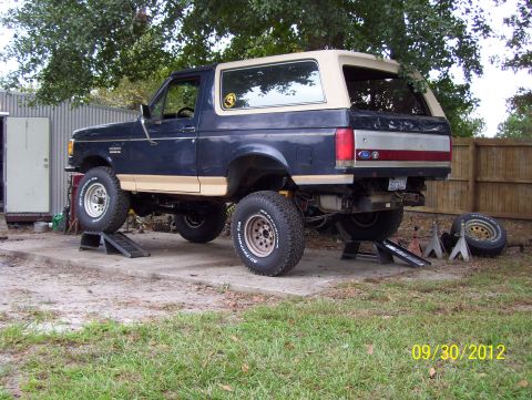 1990 Ford Bronco - 1990 Ford Bronco undergoing maintenance, raised on jack stands and ramps.